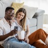 couple sitting together smiling looking at a phone
